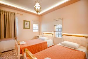 a bedroom with two beds and a window at Villa Kadith Agios Gordios in Agios Gordios +48 photos