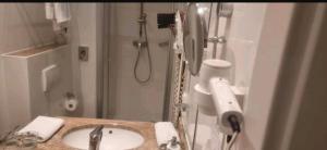 a bathroom with a sink and a shower at Hotel La Strada & Sultan in Murnau am Staffelsee +19 photos