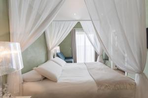 a bedroom with a canopy bed with a window at Quaint Boutique Hotel Xewkija in Xewkija