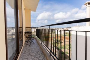 a balcony with chairs and a view of the city at Quaint Boutique Hotel Xewkija in Xewkija