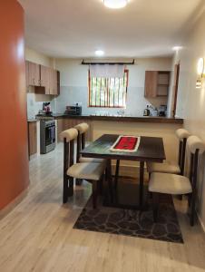 a kitchen with a dining room table and chairs at Kwame Homes in Nakuru