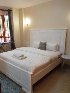 a bedroom with a large white bed with towels on it at Kwame Homes in Nakuru