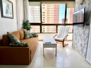 a living room with a couch and a table at Apartments 1 & 2 Bedrooms, Gemelos 2 & 4, Levante Beach by Gestaltur in Benidorm