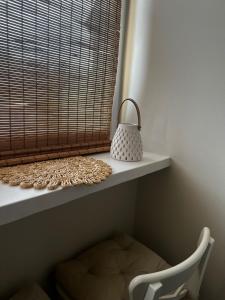 a white shelf with a chair and a bag on it at Apartament Boho Monte 60 in Sopot +1 photo