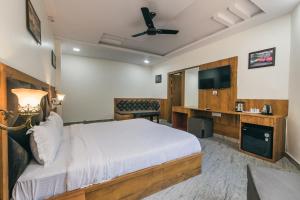a hotel room with a bed and a flat screen tv at Serenity Hill Resort Near 2Km Fateh Sagar Lake Udaipur in Udaipur
