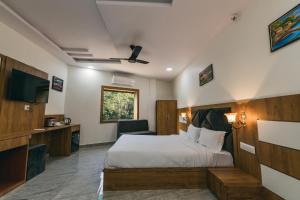 a hotel room with a bed and a television at Serenity Hill Resort Near 2Km Fateh Sagar Lake Udaipur in Udaipur