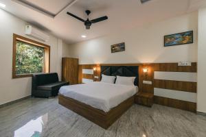 a bedroom with a bed and a chair in it at Serenity Hill Resort Near 2Km Fateh Sagar Lake Udaipur in Udaipur +27 photos
