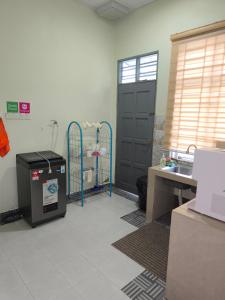 a room with a kitchen with a sink and a door at Dsurau Homestay in Kota Bharu