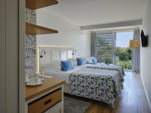 a bedroom with two beds and a window at Amadria Park Beach Hotel Jure in Šibenik +35 photos