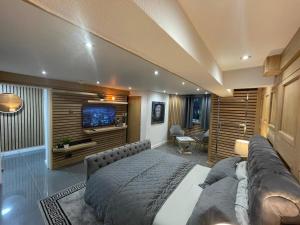 a bedroom with a large bed and a television at Hendham House - Near Etihad Stadium, CoOp Live Arena, AO Arena, Piccadilly Train Station & Manchester City Centre in Manchester
