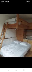 a bedroom with two bunk beds with white sheets at Le gîte du Val in Flumet