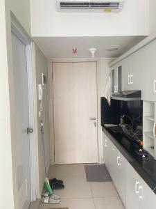 a kitchen with a mop next to a door at Springlake apartment b in Rawabugel