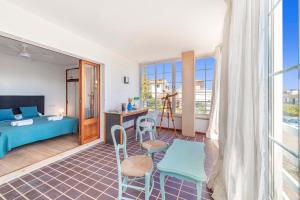 a room with a bed and a desk and chairs at Villa Magraner by Sealand Villas in Can Picafort