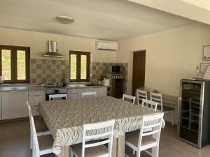 a kitchen with a table and a table and chairs at Vitál Guesthouse in Almamellék +25 photos