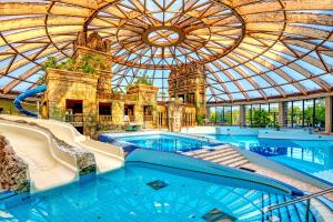 an indoor swimming pool with a glass domed ceiling at Aquaworld Resort Budapest in Budapest