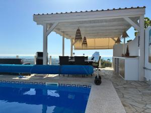 a pavilion over a swimming pool next to a house at Ons Spanje in Calpe