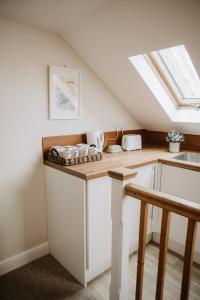 a kitchen with white cabinets and a skylight at Room 2 at The Firs in Backwell