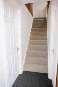a stairway with a white door and a staircase at Room 2 at The Firs in Backwell
