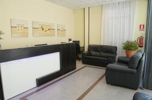 a waiting room with a fireplace and two chairs at Hotel Barajas Plaza in Madrid