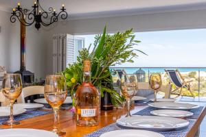 a table with glasses and a bottle of wine on it at Whales Rest in Pearly Beach