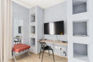 a room with a desk and a tv on a wall at Quaint Boutique Hotel Xewkija in Xewkija