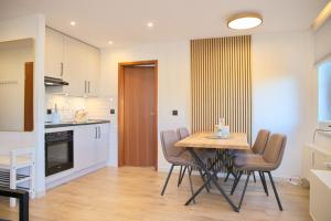 a kitchen and dining room with a table and chairs at Haus Titania App 4 inkl WLAN in Grömitz +8 photos