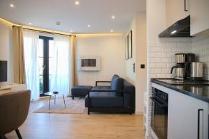 a kitchen and a living room with a couch at Haus Titania App 4 inkl WLAN in Grömitz