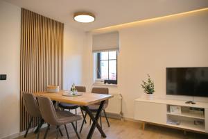 a living room with a dining room table and a television at Haus Titania App 4 inkl WLAN in Grömitz