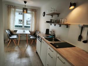 a kitchen with a sink and a table with chairs at SPITZAUERs APARTMENTs in Anthering