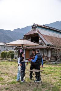 a group of people standing around a picnic table at 淵明庵 in Fujikawa