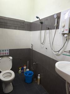 a bathroom with a shower and a toilet and a sink at Dsurau Homestay in Kota Bharu +8 photos
