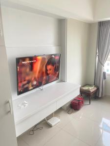a living room with a flat screen tv on a wall at Springlake apartment b in Rawabugel