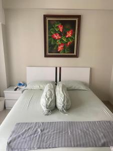 a bed with two pillows and a painting on the wall at Springlake apartment b in Rawabugel +2 photos