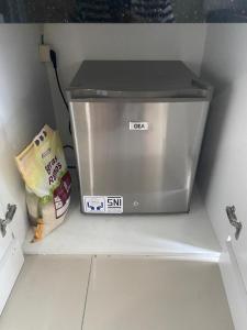 a small refrigerator sitting in a shelf in a kitchen at Springlake apartment b in Rawabugel