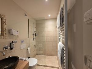 a bathroom with a shower and a toilet and a sink at Hôtel Eze Hermitage in Éze +61 photos