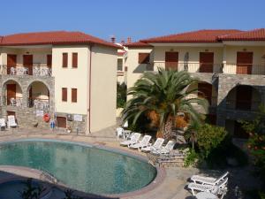 a resort with a pool and chairs and a building at Hotel Argo in Siviri