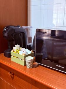 a desk with a television and a coffee maker at Antonella's house in Casteldaccia