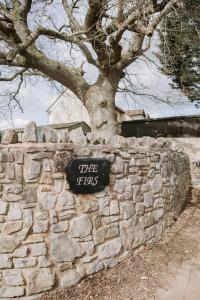 a stone wall with a tree on top of it at Room 2 at The Firs in Backwell