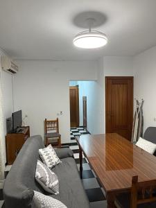 a living room with a couch and a wooden table at Casa en la Huertecilla in Lora del Río