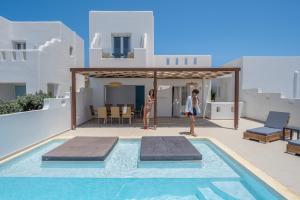 a man and a woman standing next to a swimming pool at Depis luxury private villas in Plaka