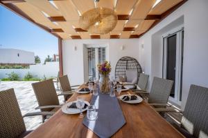 a dining room with a wooden table and chairs at Depis luxury private villas in Plaka