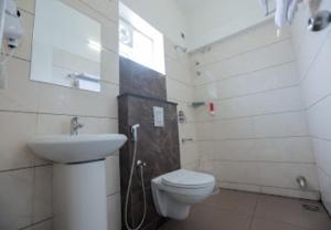 a bathroom with a toilet and a sink at Nandha Grande in Udumalaippettai