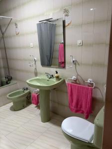 a bathroom with a sink and a toilet and a mirror at Casa en la Huertecilla in Lora del Río