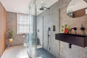 a bathroom with a shower and a sink and a mirror at Central spacious town house in Exeter +12 photos