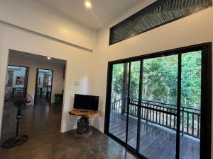 a room with a balcony with a computer on a table at Nutmeg Cottage SIARGAO 2BR exclusive whole house in General Luna