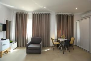 a living room with a chair and a table at Hotel SUNSET GL in Vlorë