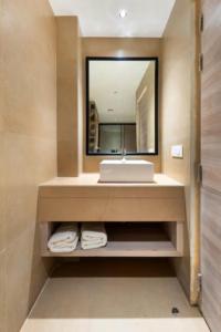 a bathroom with a sink and a mirror at OPO Premier Ro'yal Delhi Airport - FREE Airport Pickup Or Drop in New Delhi