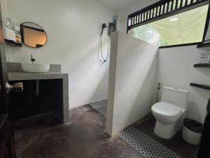 a bathroom with a toilet and a sink at Nutmeg Cottage SIARGAO 2BR exclusive whole house in General Luna +15 photos
