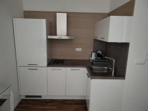 a white kitchen with white cabinets and a sink at Oliver apartmán 6 in Štrbské Pleso