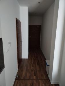 an empty hallway with a wooden floor and a door at Oliver apartmán 6 in Štrbské Pleso